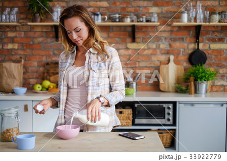 Woman making cereals for a breakfast Woman making cereals for a breakfast 33922779