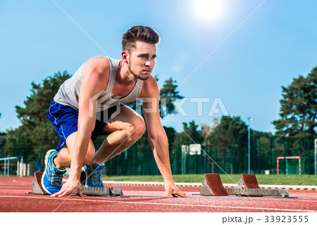 Track and field sprinter on starting point at Track and field sprinter on starting point at 33923555
