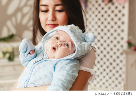 Loving Asian Mother Holding Baby Son At Home 33923895