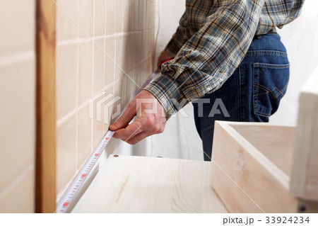 Contractor measuring a kitchen Contractor measuring a kitchen 33924234