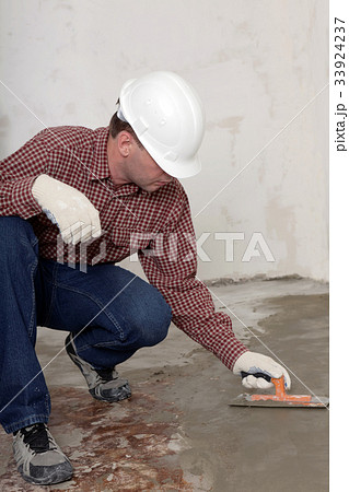 Construction worker spreading concrete Construction worker spreading concrete 33924237