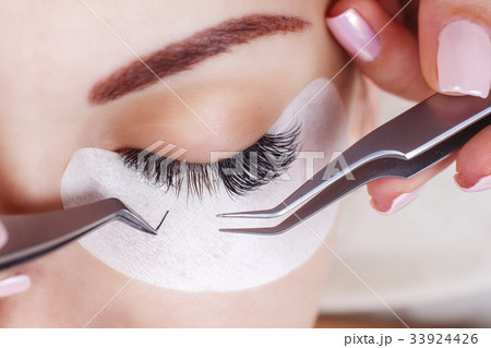 Eyelash Extension Procedure. Woman Eye with Long 33924426