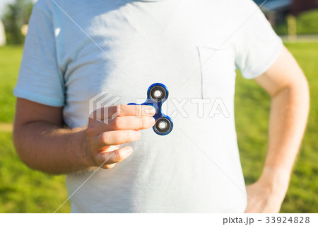 Man hand holding popular fidget spinner toy, Man hand holding popular fidget spinner toy, 33924828