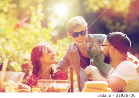 happy friends having dinner at summer garden party 33926706