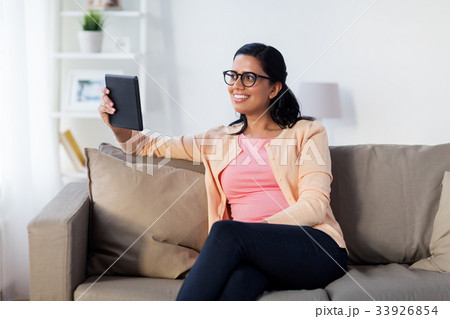 happy indian woman with tablet pc at home 33926854