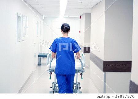 nurse carrying hospital gurney to emergency room 33927970