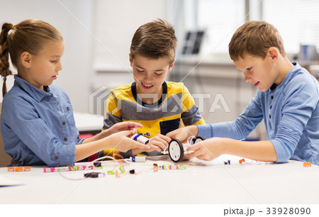 happy children building robots at robotics school 33928090