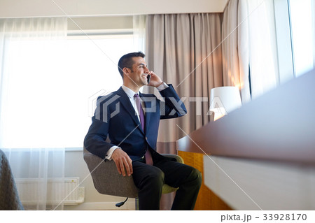businessman calling on smartphone at hotel room businessman calling on smartphone at hotel room 33928170