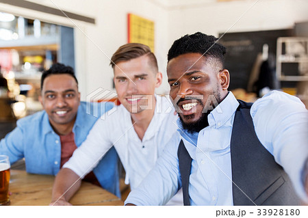 friends taking selfie and drinking beer at bar friends taking selfie and drinking beer at bar 33928180