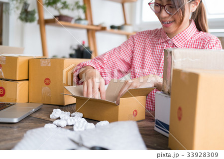 start up small business owner packing cardboard box at workplace. freelance woman entrepreneur SME seller prepare parcel box of product for deliver to customer. Online selling, internet marketing, e-commerce, shipping concept 33928309