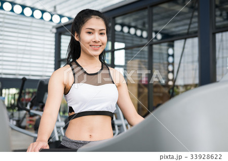 young woman execute exercise in fitness center. female athlete walking on treadmill in gym. sporty girl working out in health club. young woman execute exercise in fitness center. female athlete walking on treadmill in gym. sporty girl working out in health club. 33928622