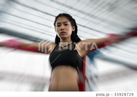 young woman prepare for exercise in fitness center. female boxer posing in boxing ring in gym. sporty girl resting after working out in health club. martial arts, muay thai concept young woman prepare for exercise in fitness center. female boxer posing in boxing ring in gym. sporty girl resting after working out in health club. martial arts, muay thai concept 33928729
