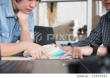 graphic or interior designer choosing a colour from color swatch sampler or catalogue palette guide 33929181