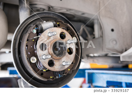 car suspension & bearing of wheel hub in auto service maintenance. Car lift up by hydraulic, waiting for tire replacement in garage. punched wheel concept car suspension & bearing of wheel hub in auto service maintenance. Car lift up by hydraulic, waiting for tire replacement in garage. punched wheel concept 33929187