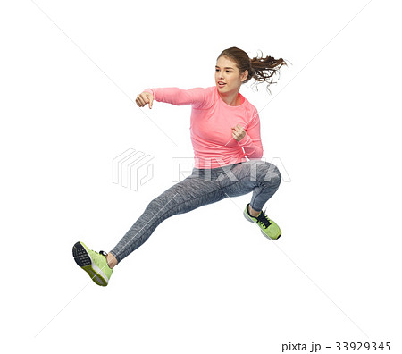 happy sporty young woman jumping in fighting pose 33929345