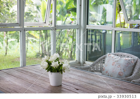 bouquet of white siam tulip flower in vase on wood table near window with garden view. decoration and interior bouquet of white siam tulip flower in vase on wood table near window with garden view. decoration and interior 33930513