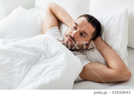 man lying in bed at home man lying in bed at home 33930645