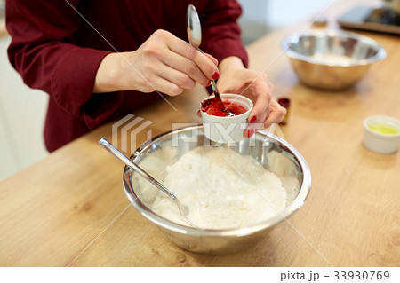 chef hands adding food color into bowl with flour chef hands adding food color into bowl with flour 33930769