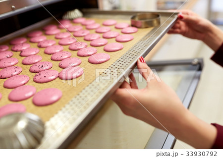 chef with macarons on oven tray at confectionery 33930792
