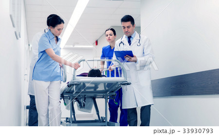 medics with woman on hospital gurney at emergency 33930793