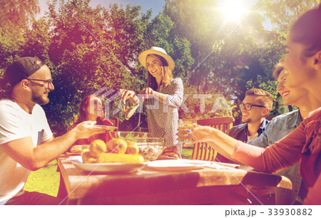 happy friends having dinner at summer garden party 33930882