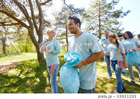 volunteers with garbage bags walking outdoors volunteers with garbage bags walking outdoors 33931203