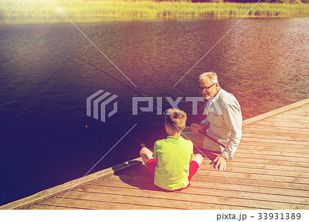 grandfather and grandson fishing on river berth 33931389