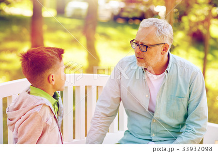 grandfather and grandson talking at summer park grandfather and grandson talking at summer park 33932098