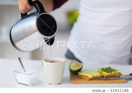 man with kettle making tea for breakfast at home 33932186