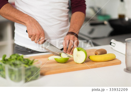 man chopping fruits and cooking at home kitchen 33932209