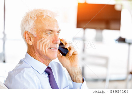 Businessman at the office with mobile phone Businessman at the office with mobile phone 33934105