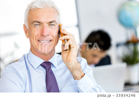 Businessman at the office with mobile phone 33934246