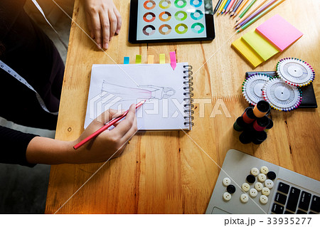 young women working as fashion designer drawing sketches for clo 33935277