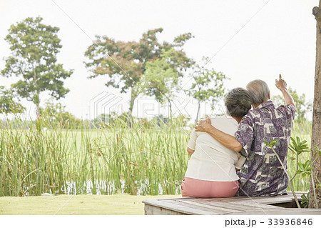 A picture of an elderly man pointing something on sky to his wife A picture of an elderly man pointing something on sky to his wife 33936846