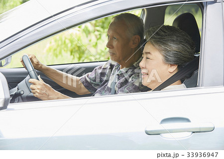 senior couple is driving car and smiling 33936947