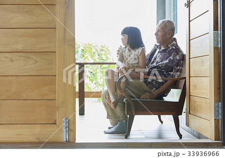 a grandfather and a child are sitting and looking at something a grandfather and a child are sitting and looking at something 33936966
