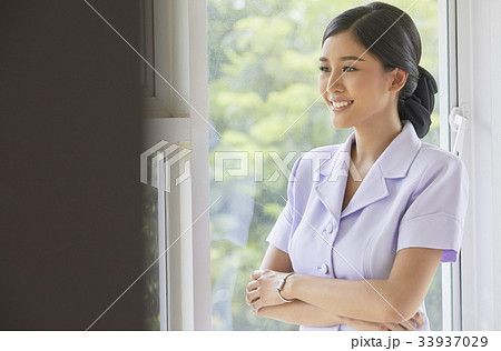 A nurse is crossing her arms and smiling 33937029