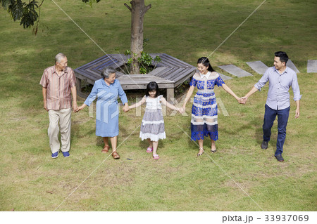 A happy family is having fun together in front of the tree in the garden. A happy family is having fun together in front of the tree in the garden. 33937069