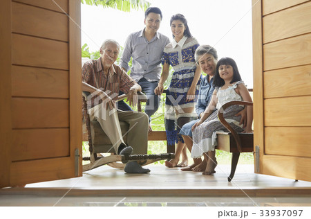 An extended family is posing happily on the balcony. 33937097