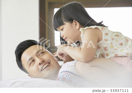 a little girl is touching her father's cheek by her fingers. a little girl is touching her father's cheek by her fingers. 33937111