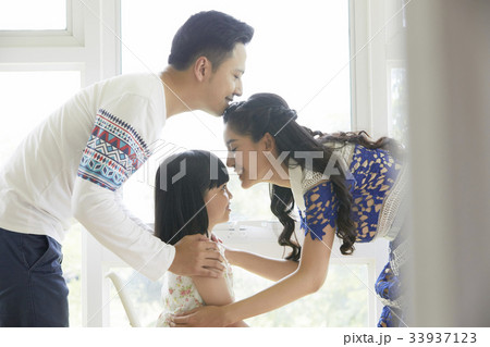a happy family of parents and a little daughter is kissing each other 33937123