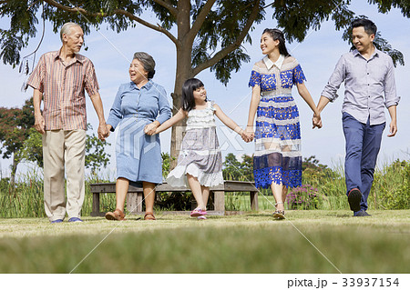 an extended family is walking outdoors and smiling happily an extended family is walking outdoors and smiling happily 33937154