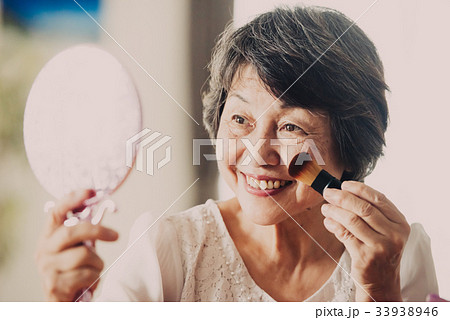 頬紅を塗る日本人シニア女性 33938946