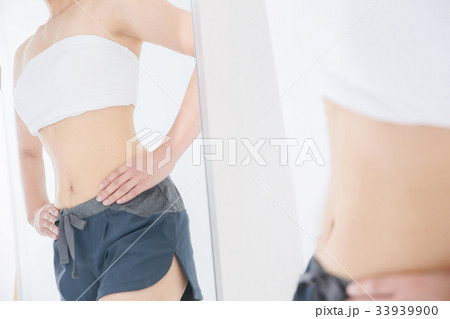 鏡越しに体を見る女性 鏡越しに体を見る女性 33939900