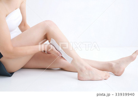 ふくらはぎに湿布を貼る女性の写真素材
