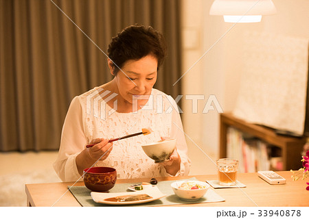 一人で夕食を食べるシニア女性の写真素材