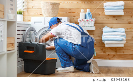 working man   plumber repairs  washing machine in   laundry 33943168