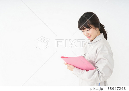 工場で働く作業服姿の女性 工場で働く作業服姿の女性 33947248