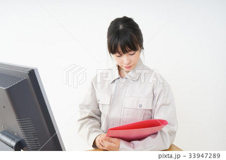 工場で働く作業服姿の女性 工場で働く作業服姿の女性 33947289