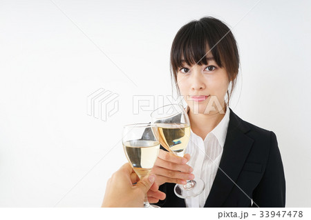 スーツ姿でお酒を飲む若い女性 スーツ姿でお酒を飲む若い女性 33947478